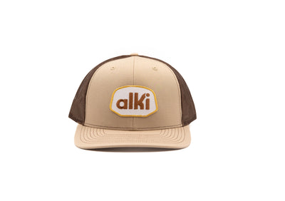 khaki and brown trucker hat with alki patch